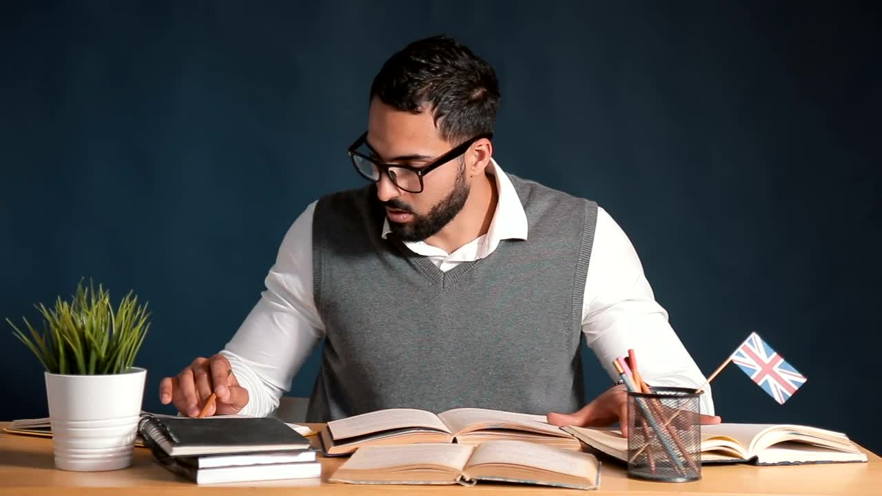 Free Video Stock teacher works at desk in classroom with chalkboard background Live Wallpaper