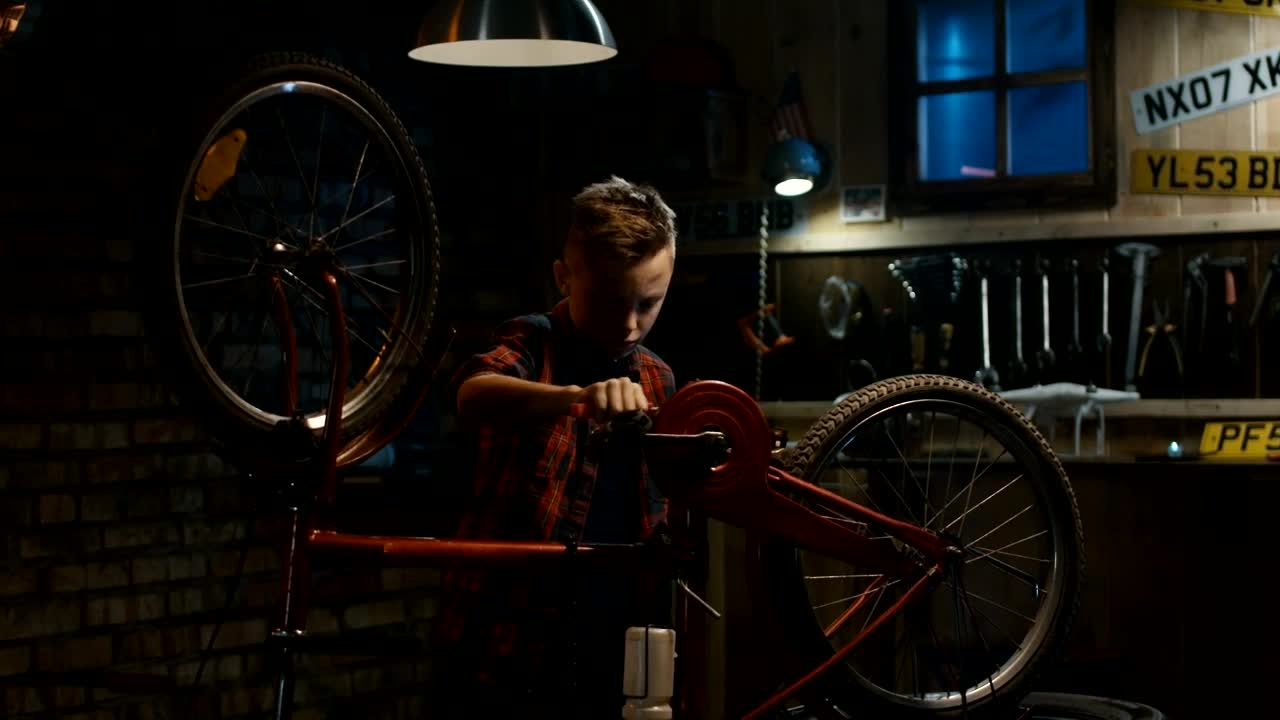 Free Video Stock teen boy repairing his bicycle in the garage Live Wallpaper