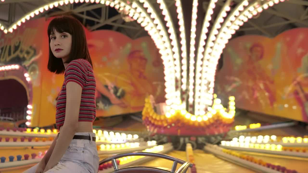 Free Video Stock teenage woman sitting in a mechanical fair game with the Live Wallpaper