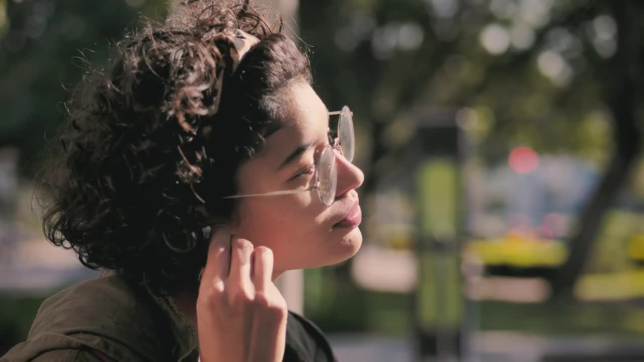 Free Video Stock teenager putting on headphones in the park Live Wallpaper