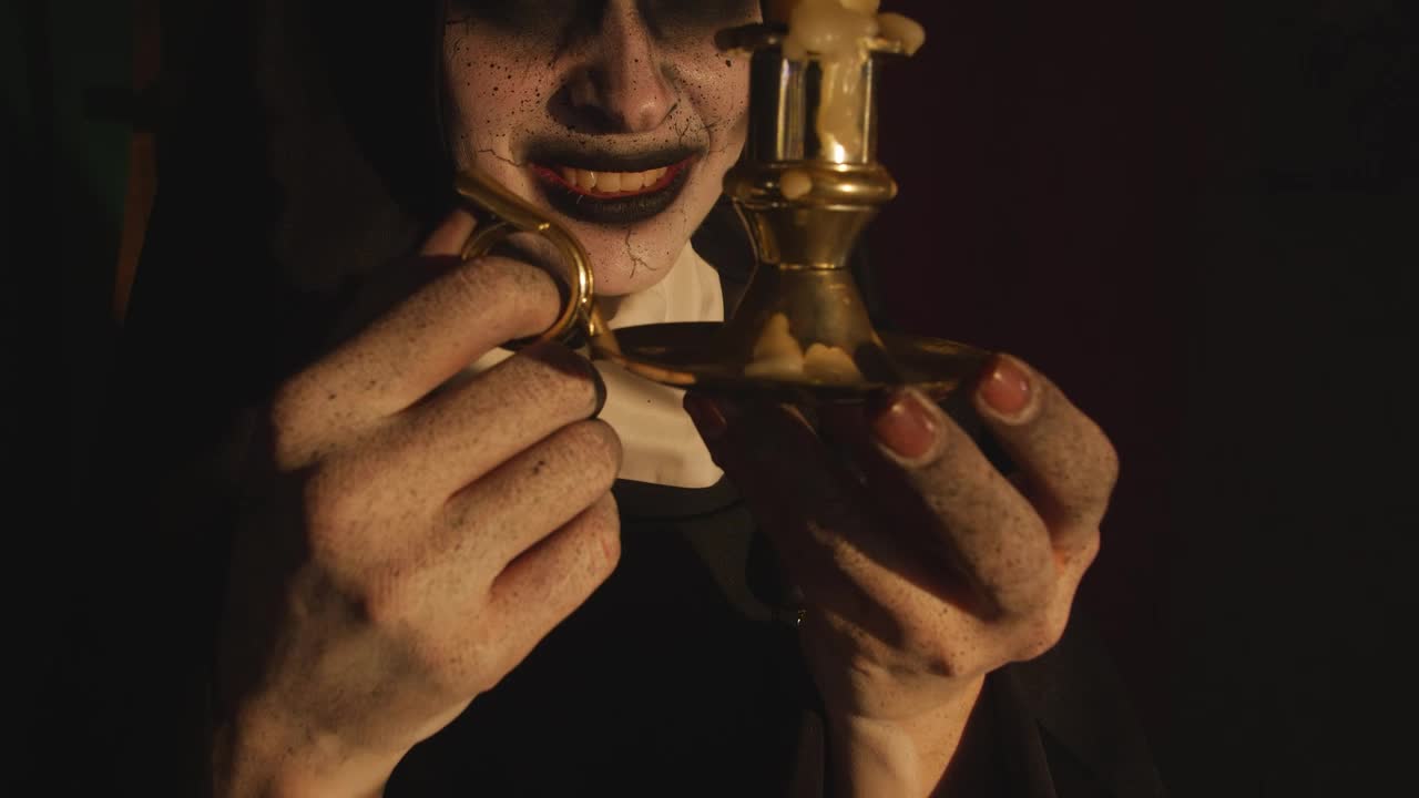 Free Video Stock terrifying nun looking at a candle in her hands Live Wallpaper