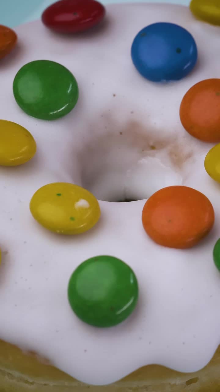 Free Video Stock texture of a glazed donut with colorful chocolates rotating Live Wallpaper