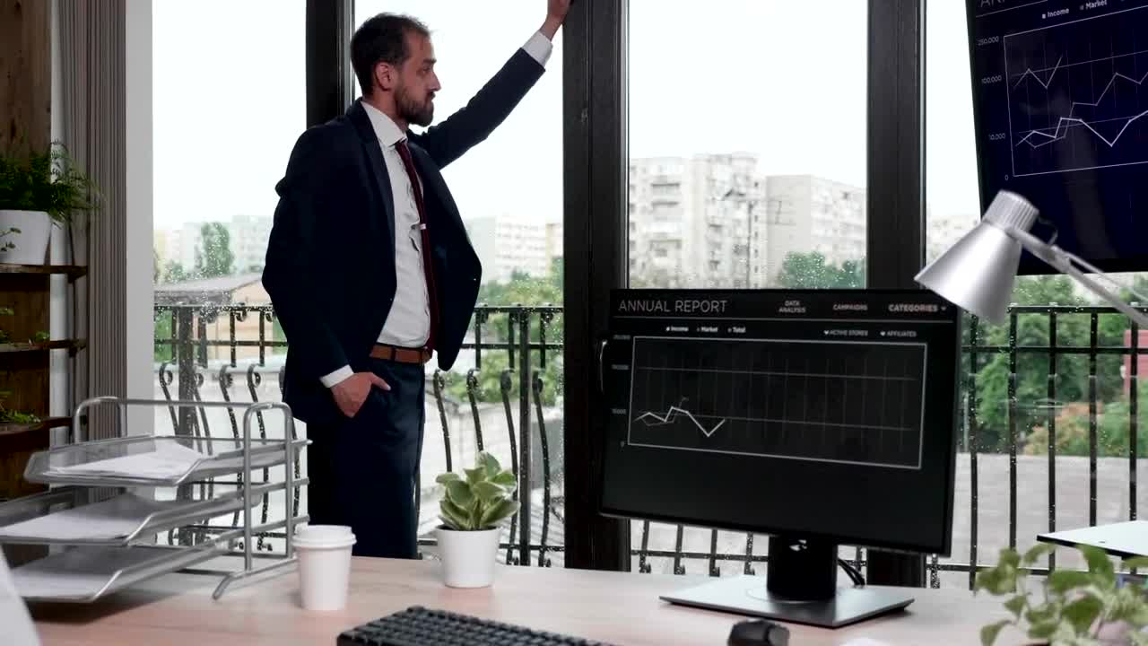 Free Video Stock thinking businessman stands by windows in office Live Wallpaper