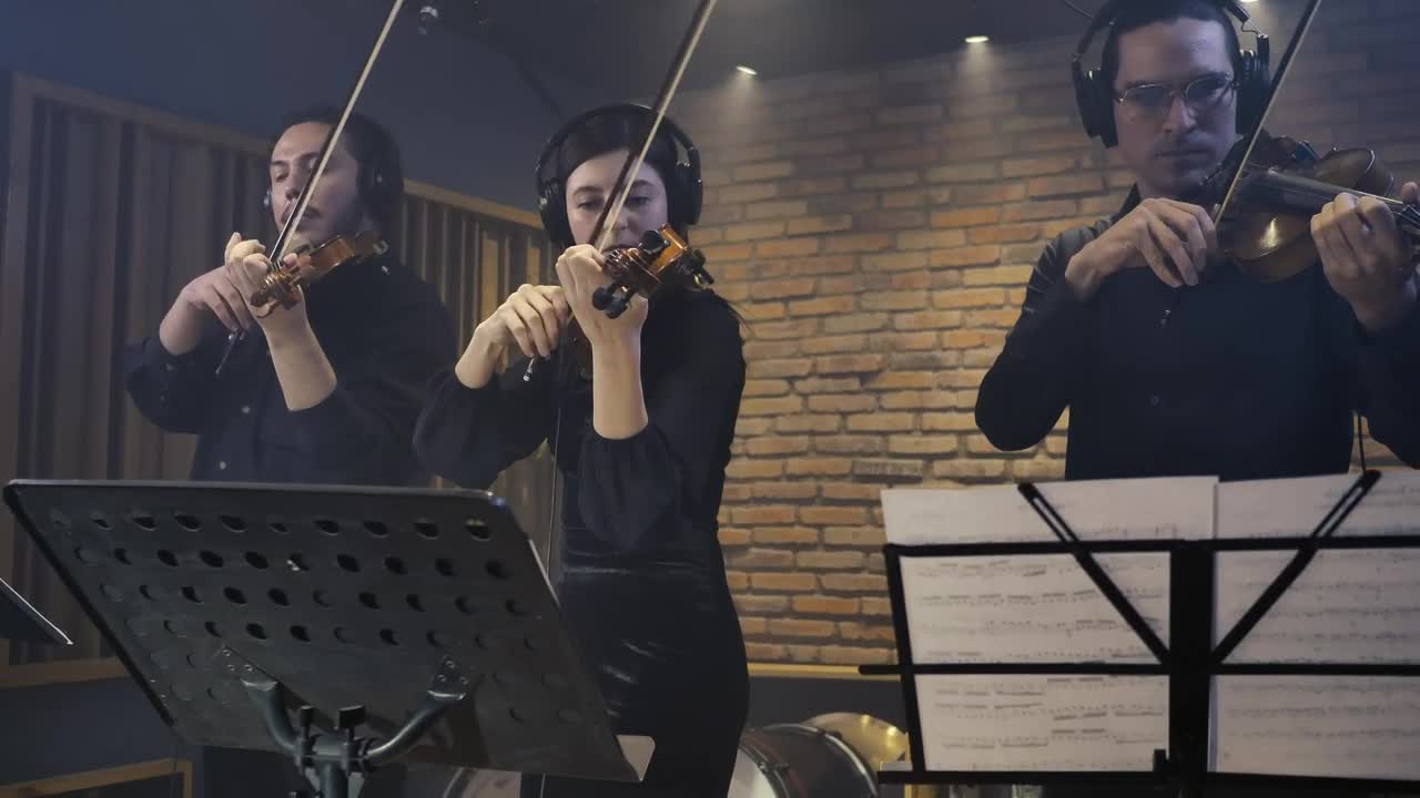 Free Video Stock three expert violinists playing together in a studio Live Wallpaper