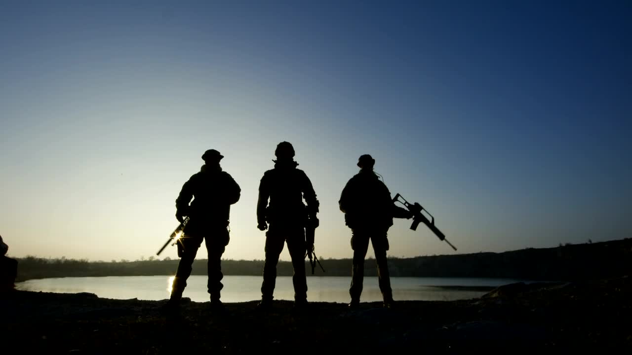 Free Video Stock three soldier silhouettes posign with guns Live Wallpaper