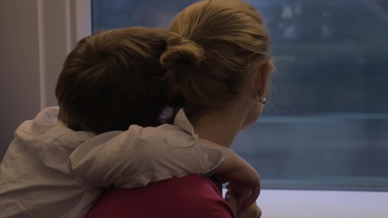 Free Video Stock tired boy holding onto his mother Live Wallpaper