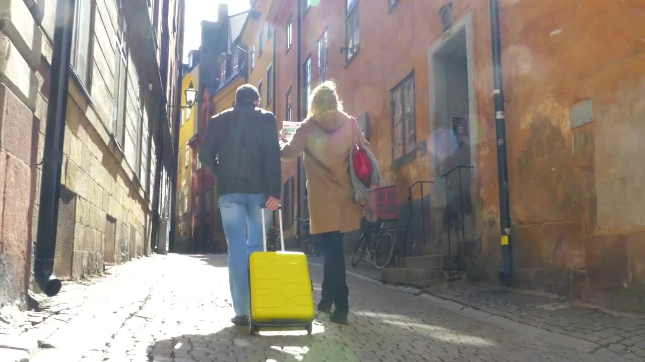 Free Video Stock tourists walking through a city with their luggage Live Wallpaper
