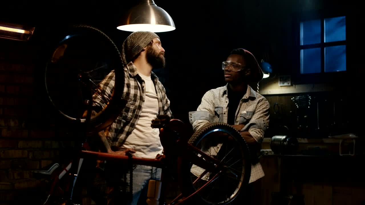 Free Video Stock tow young man talking in a bicycle repair shop Live Wallpaper