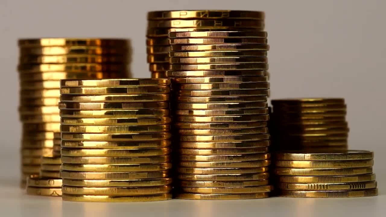 Free Video Stock towers of golden coins rotating on a gray background Live Wallpaper