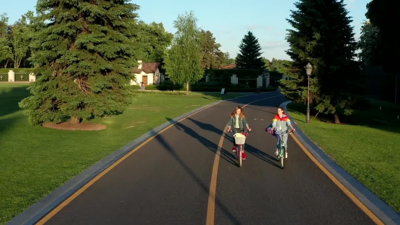 Free Stock Video Two Women Cycling Down A Road In The Suburbs Live Wallpaper