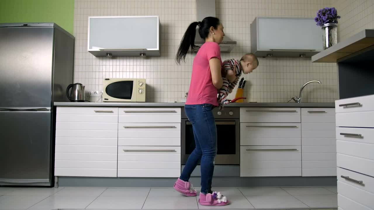 Free Stock Video Young Woman Cooking In A Kitchen Carrying Her Baby Live Wallpaper