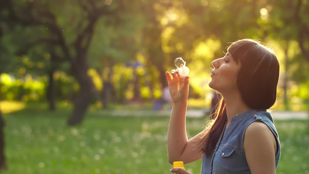 Free Stock Video Young Woman Blowing Bubbles In A Park At Sunset Live Wallpaper