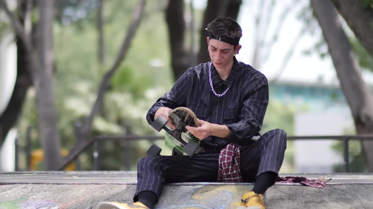 Free Stock Video Young Skateboarder Sitting Placing His Skateboard Aside Live Wallpaper