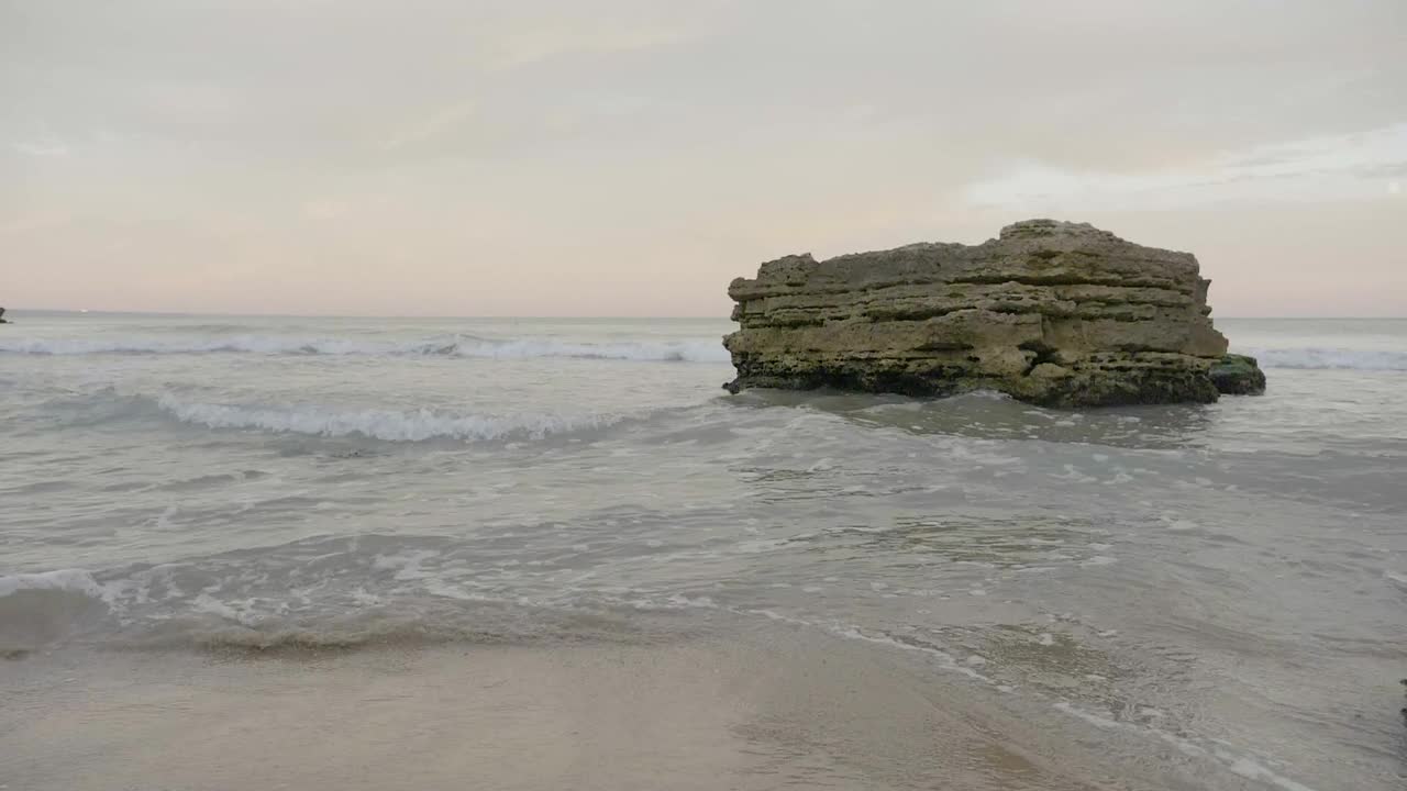   Stock Footage Waves Breaking Against A Large Rock Live Wallpaper