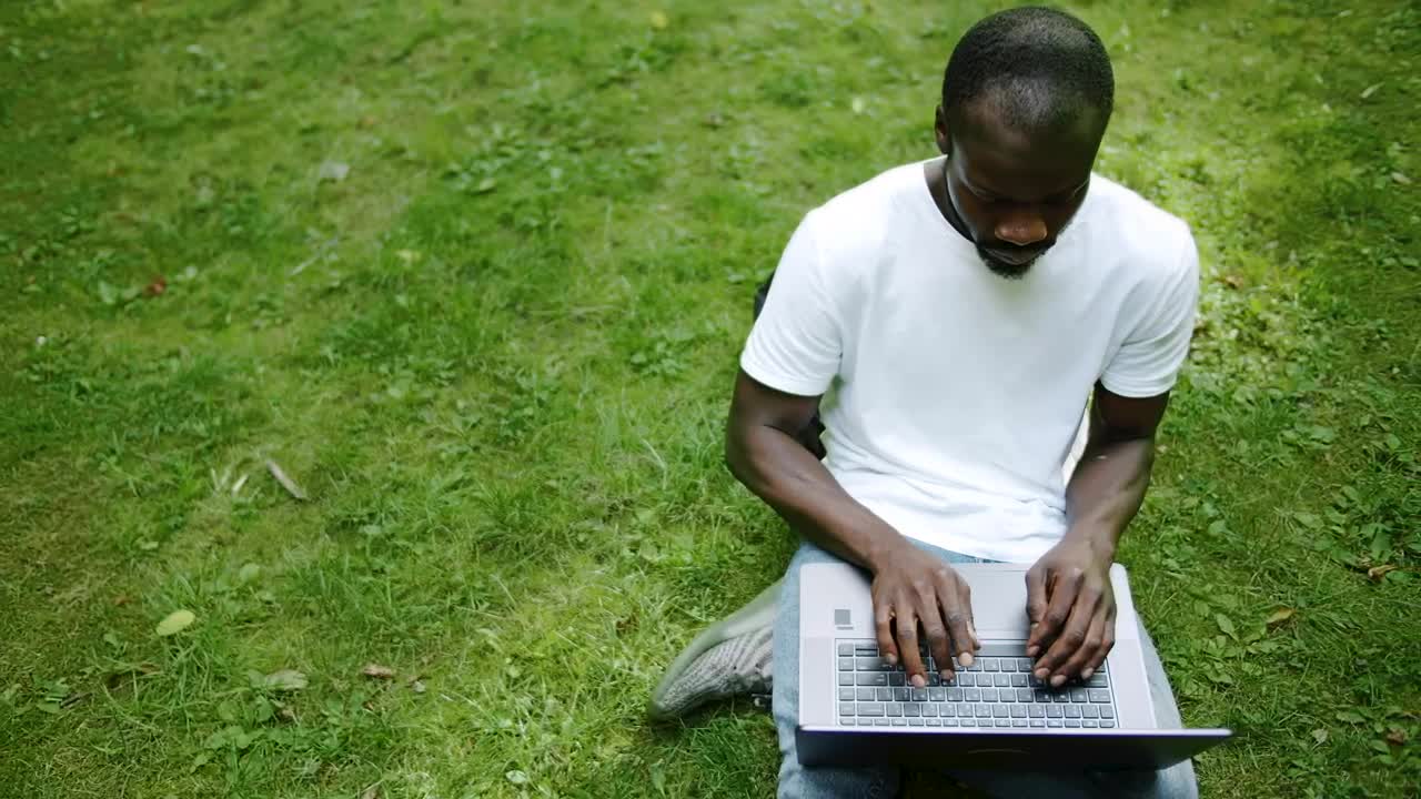   Stock Footage University Student Types On Laptop On Green Grass Live Wallpaper