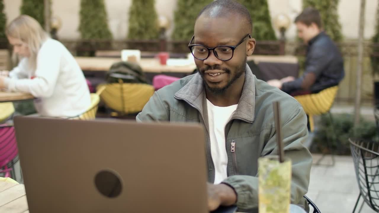   Stock Footage University Student Smiles At Laptop In Outdoor Cafeteria Live Wallpaper