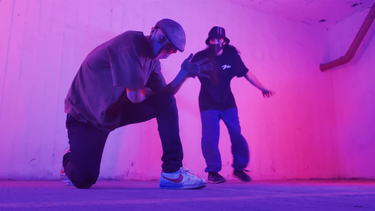   Stock Footage Two Young Men With Face Masks Dancing Hip Hop Under Live Wallpaper