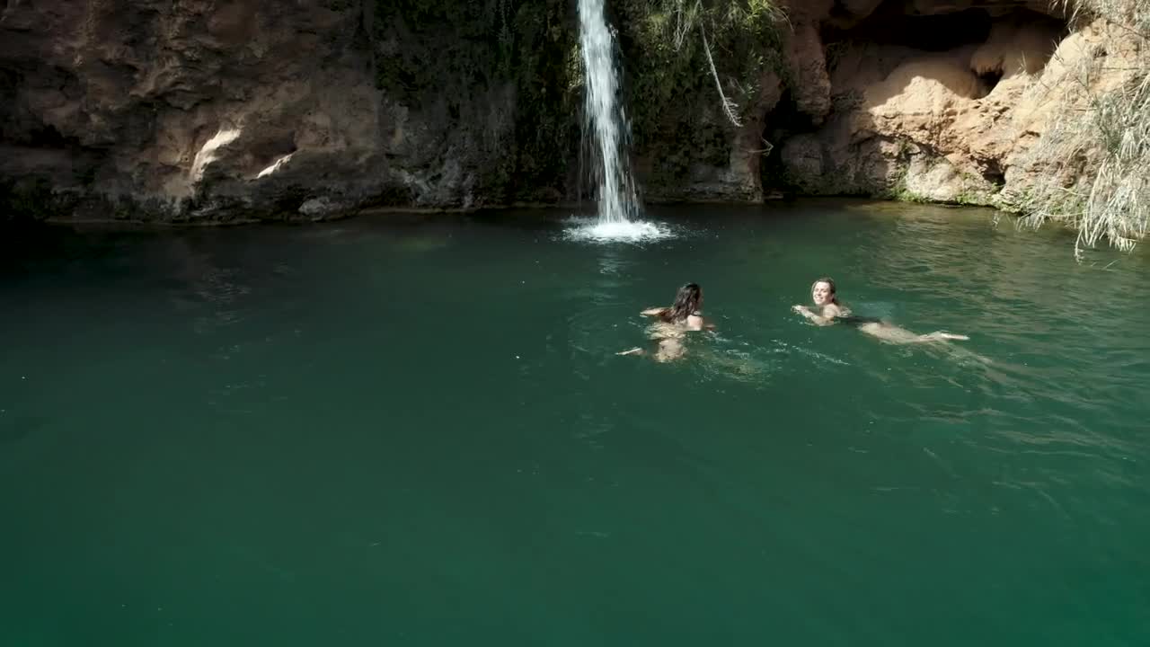   Stock Footage Two Girls Swimming In A Pond With A Waterfall Live Wallpaper
