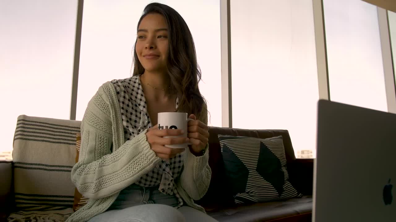 Stock Footage Woman Sits On A Couch Drinking Coffee Live Wallpaper Free