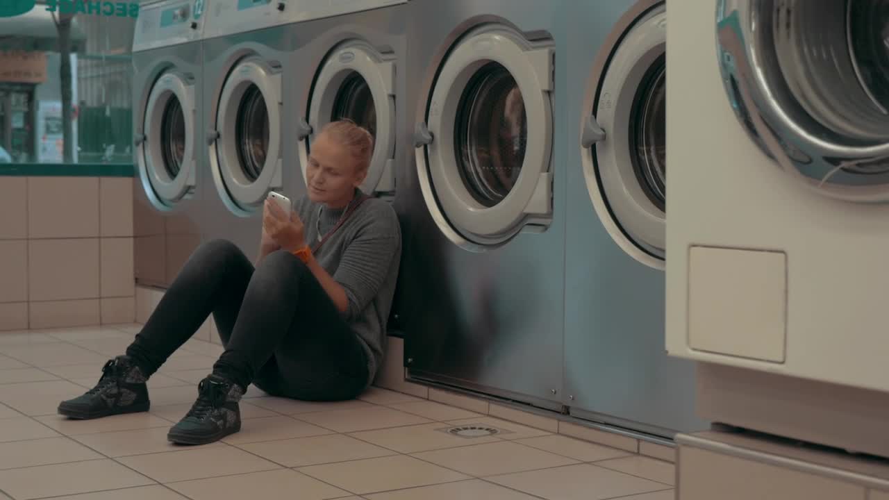 Stock Footage Woman Waiting For Her Laundry To Finish Live Wallpaper Free