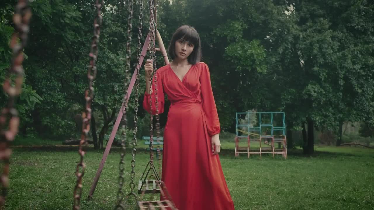 Stock Footage Woman In Red Holding A Swing In An Abandoned Park Live Wallpaper Free