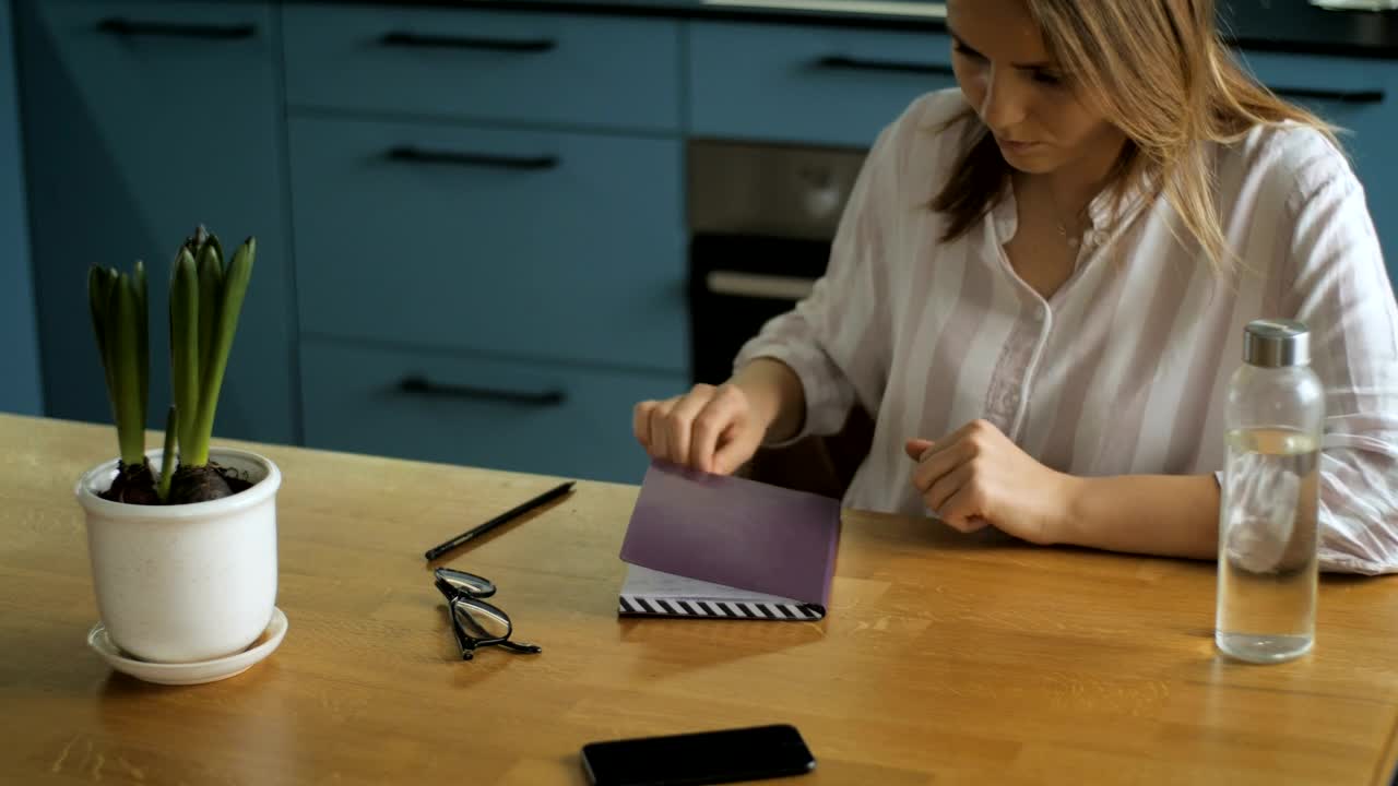 Stock Footage Young Woman Writing On A Notebook In The Kitchen Live Wallpaper Free