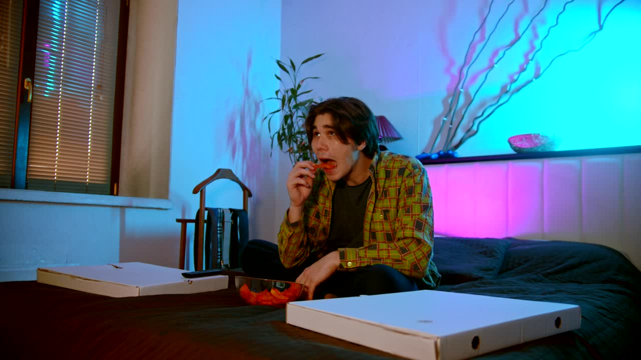 Stock Footage Young Man Eating Snacks While Watching A Movie Live Wallpaper Free