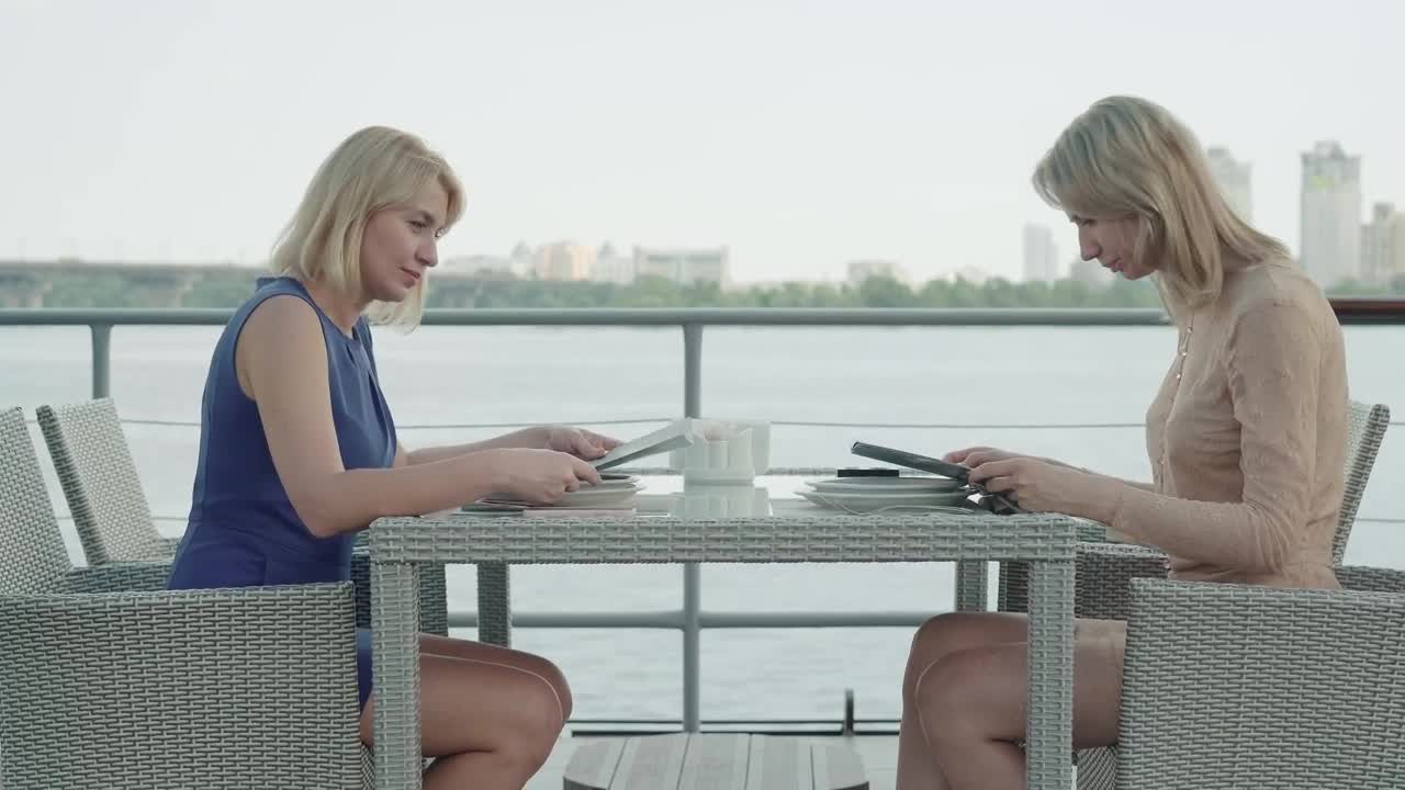 Stock Footage Women Look Over Menu At Bayside Restaurant Live Wallpaper Free