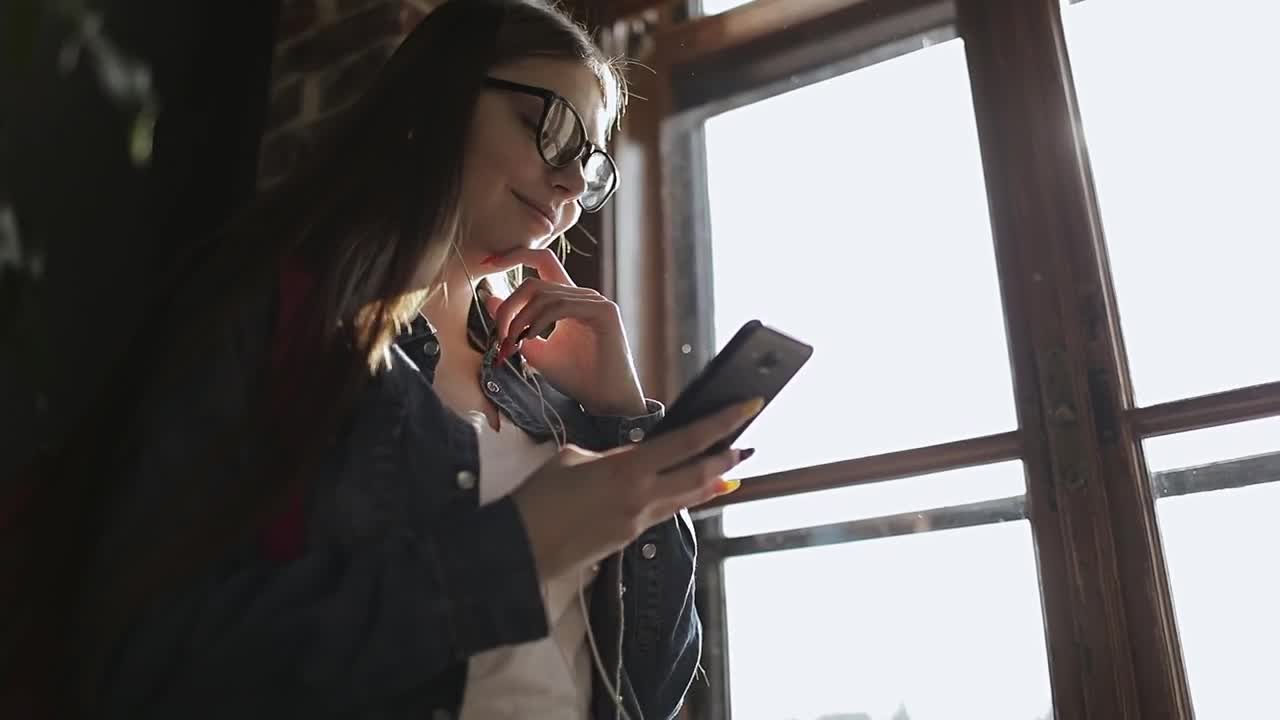Stock Footage Young Girl Smiles At Facebook Post On Mobile Phone Live Wallpaper Free