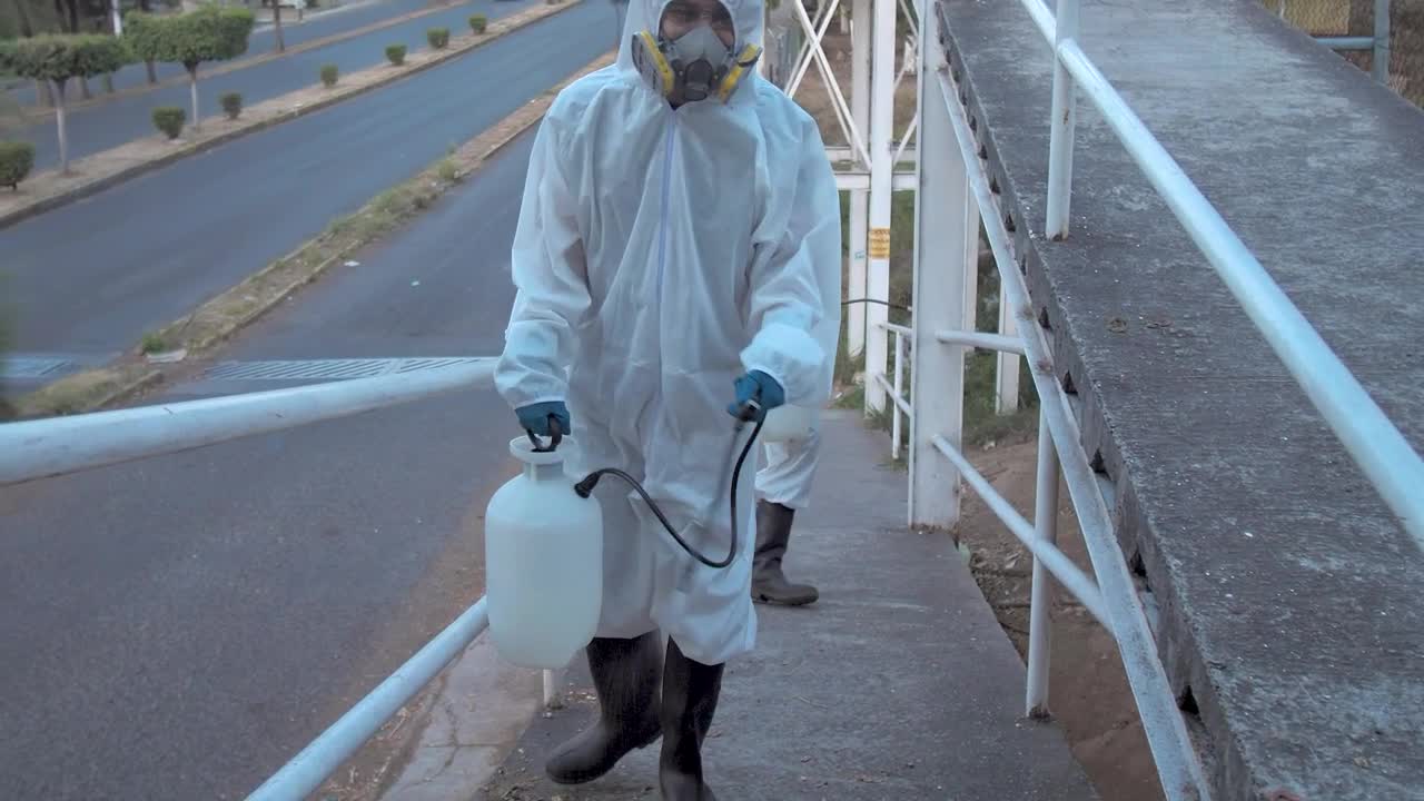 Stock Footage Workers In Hazmat Suits On A Pedestrian Bridge Live Wallpaper Free