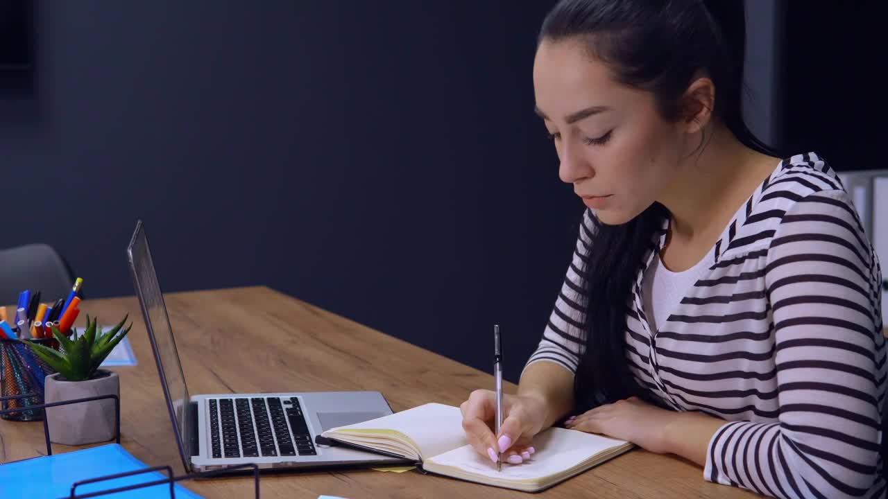 Stock Footage Young Woman Writes A List On Her Work Schedule Live Wallpaper Free