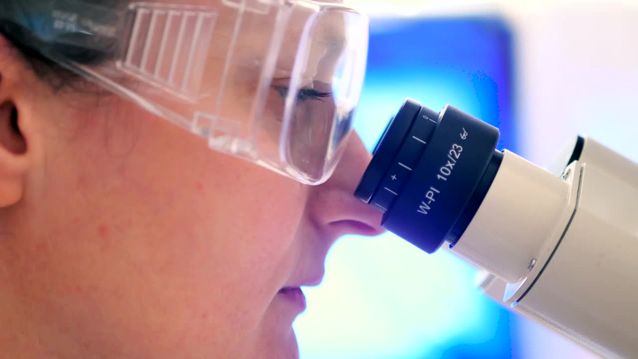 Stock Footage Woman Looking Into The Scope Of A Microscope Live Wallpaper Free
