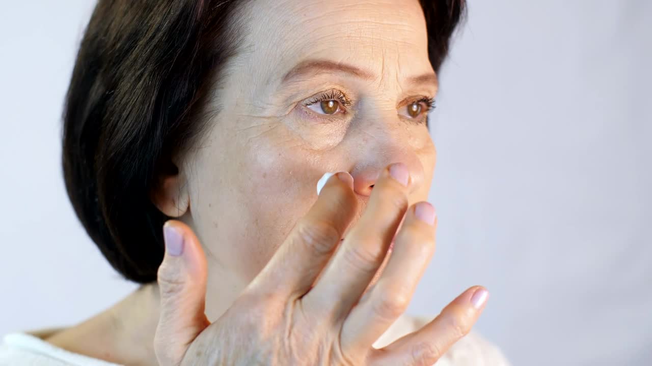 Stock Video Adult Woman Gently Putting A Cream On Her Face Live Wallpaper for PC