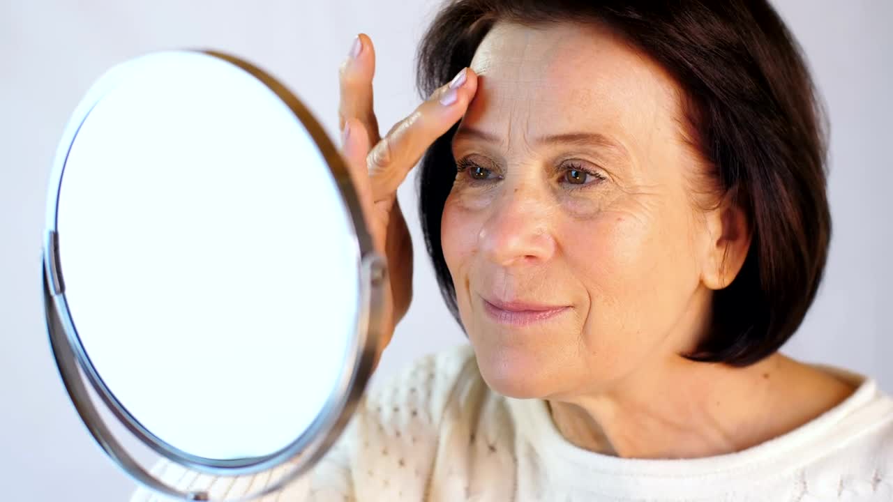 Stock Video Adult Woman Looking Her Face In Front Of A Mirror Live Wallpaper for PC
