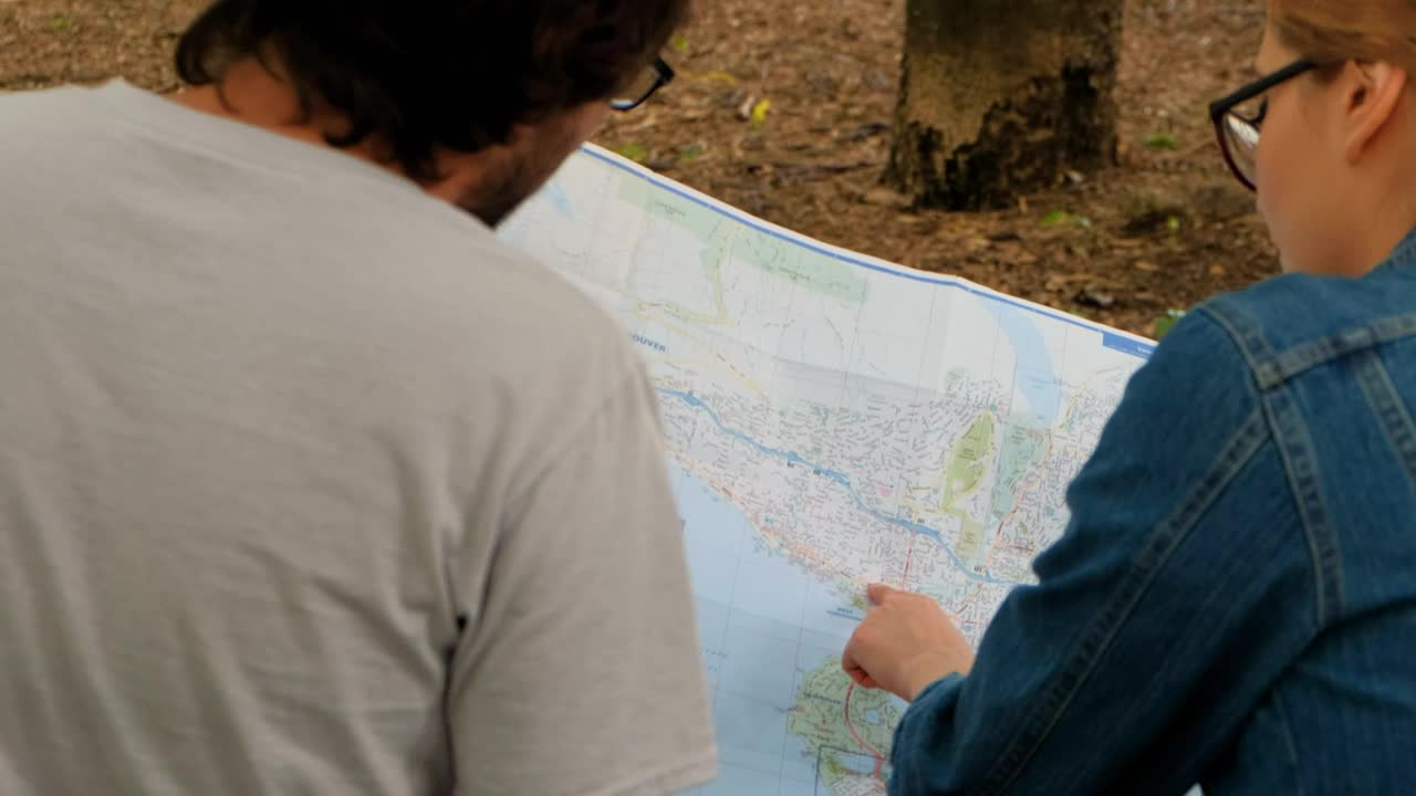 Stock Video Couple Of People Reviewing A Large Map Sitting In A Live Wallpaper For PC