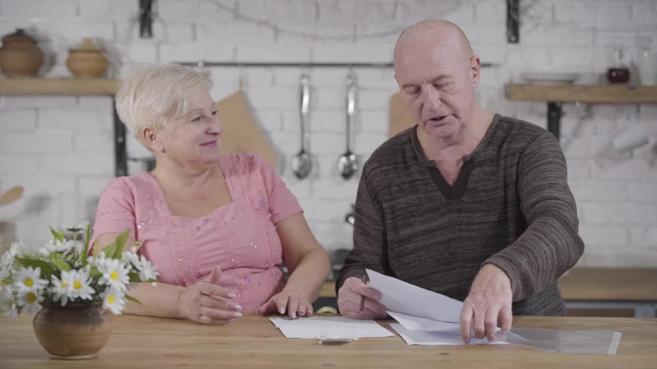 Stock Video Elderly Couple Discuss Bills In Kitchen Live Wallpaper For PC