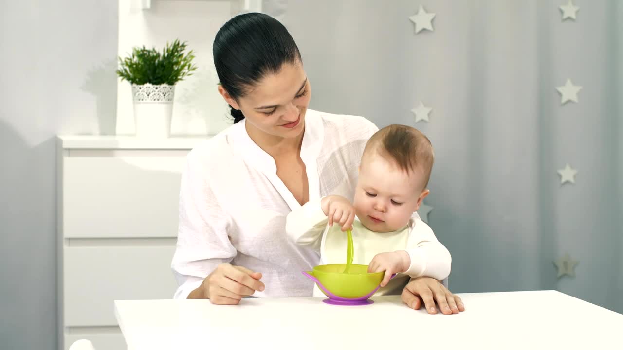Stock Video Mother Helps Her Baby To Ea Animated Wallpaper