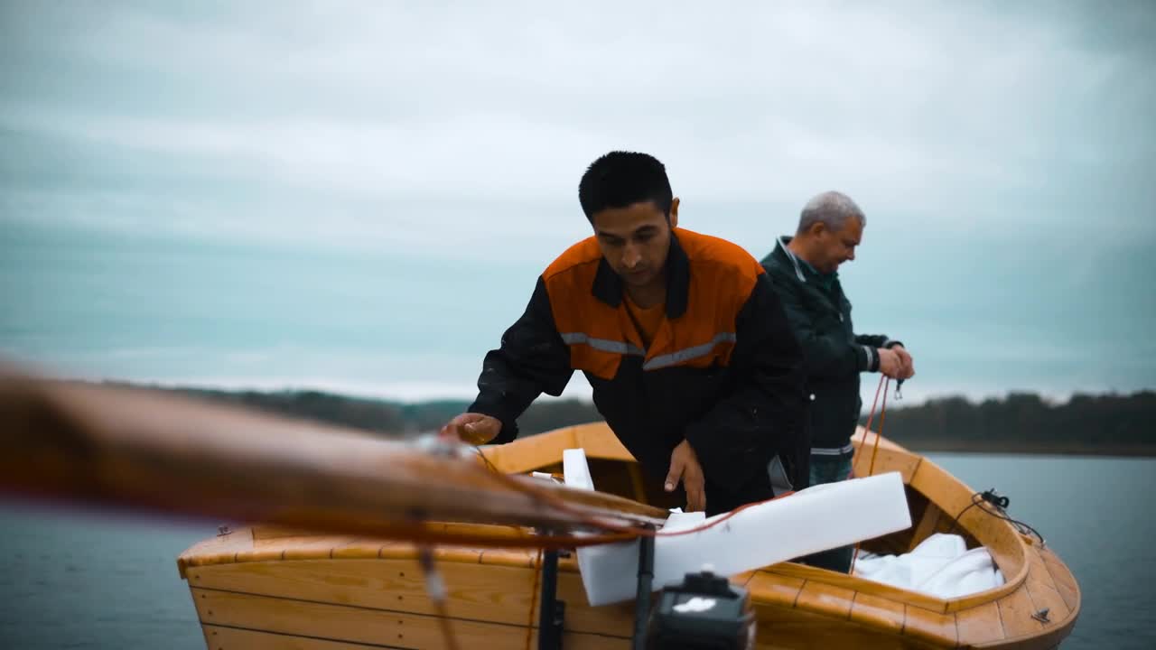 Stock Video Men Placing The Mast Of A Sailboa Animated Wallpaper