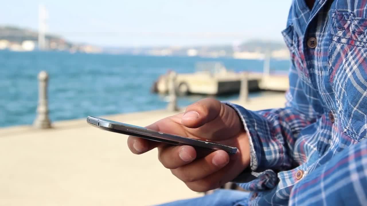 Stock Video Man With His Cell Phone In Hand Near A Sunn Animated Wallpaper