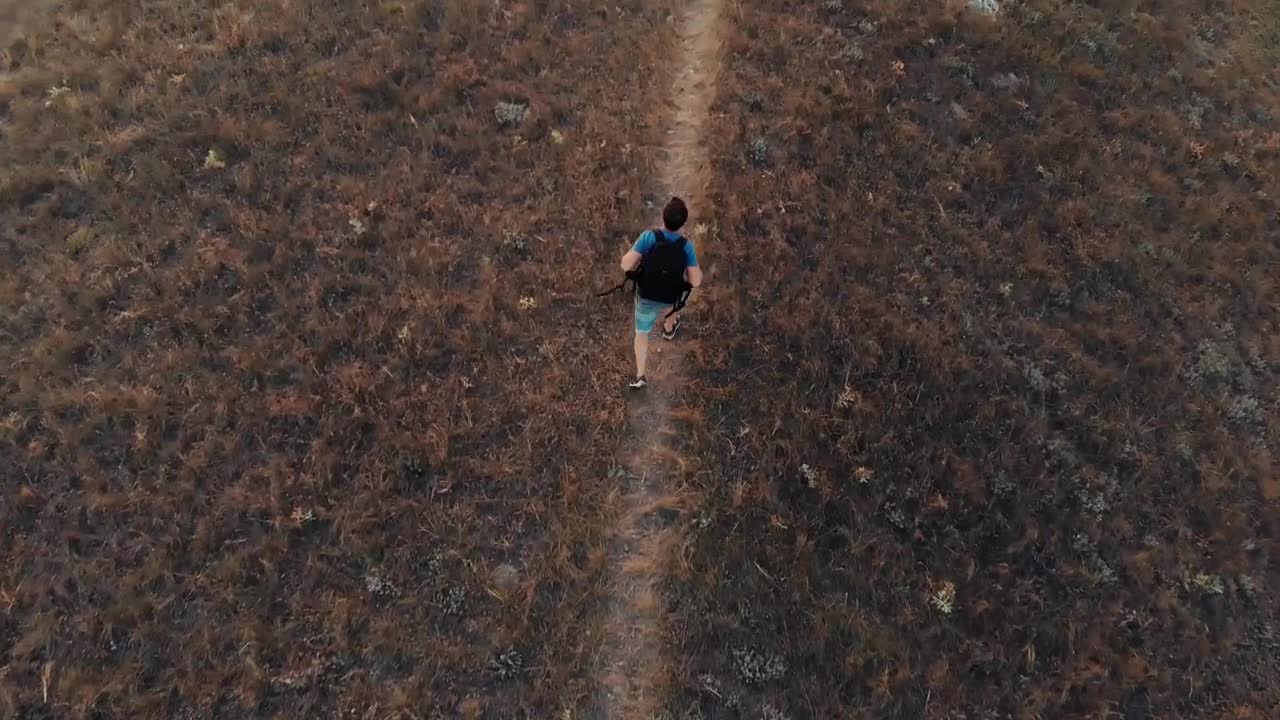 Stock Video Man Walking Down A Hill In An Aerial Sho Animated Wallpaper