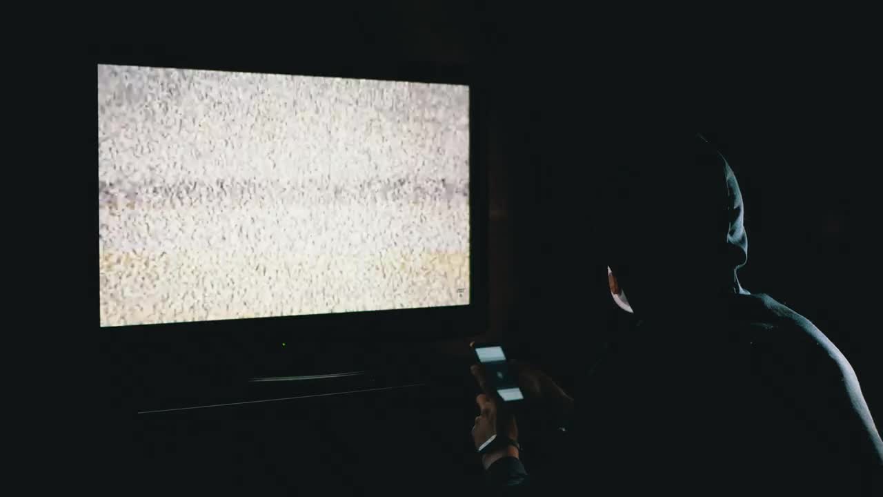Stock Video Man Scrolling A Phone In Front Of A Televisio Animated Wallpaper