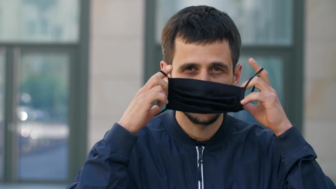 Stock Video Man Puts On A Black Face Mask On The Stree Animated Wallpaper