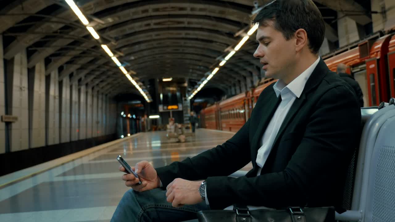 Stock Video Man On His Phone Waiting For A Trai Animated Wallpaper