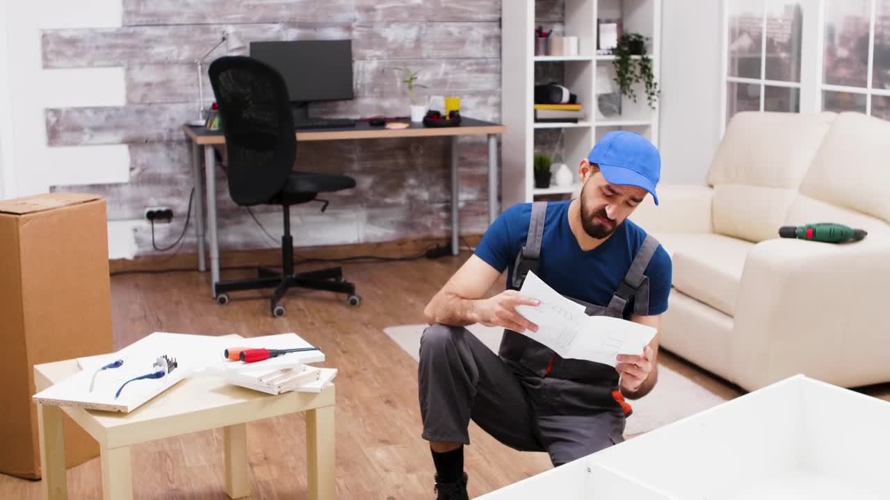 Stock Video Man Is Confused By Instructions For Furniture Assembl Animated Wallpaper