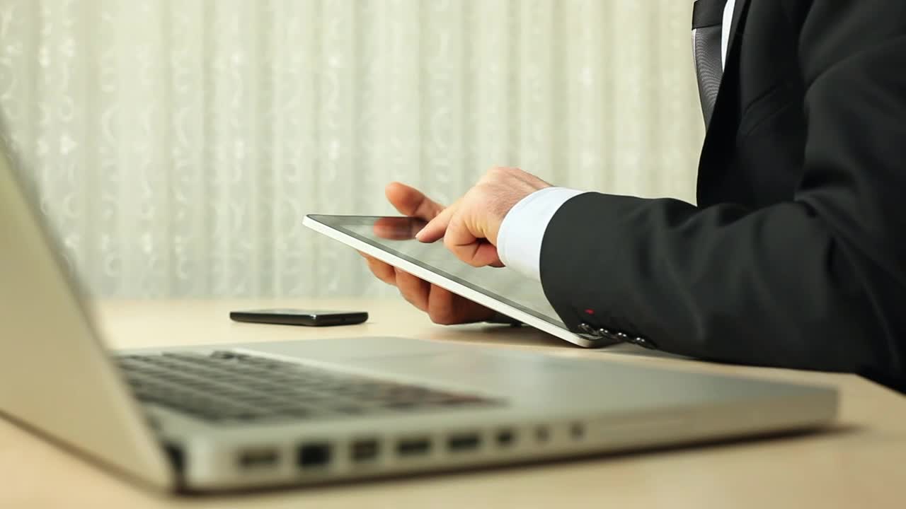 Stock Video Man In Suit Using A Tablet Next To His Compute Animated Wallpaper
