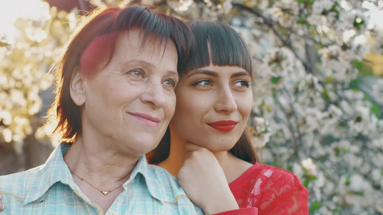 Stock Video Old Mother With Her Young Daughter In A Flower Garden Live Wallpaper