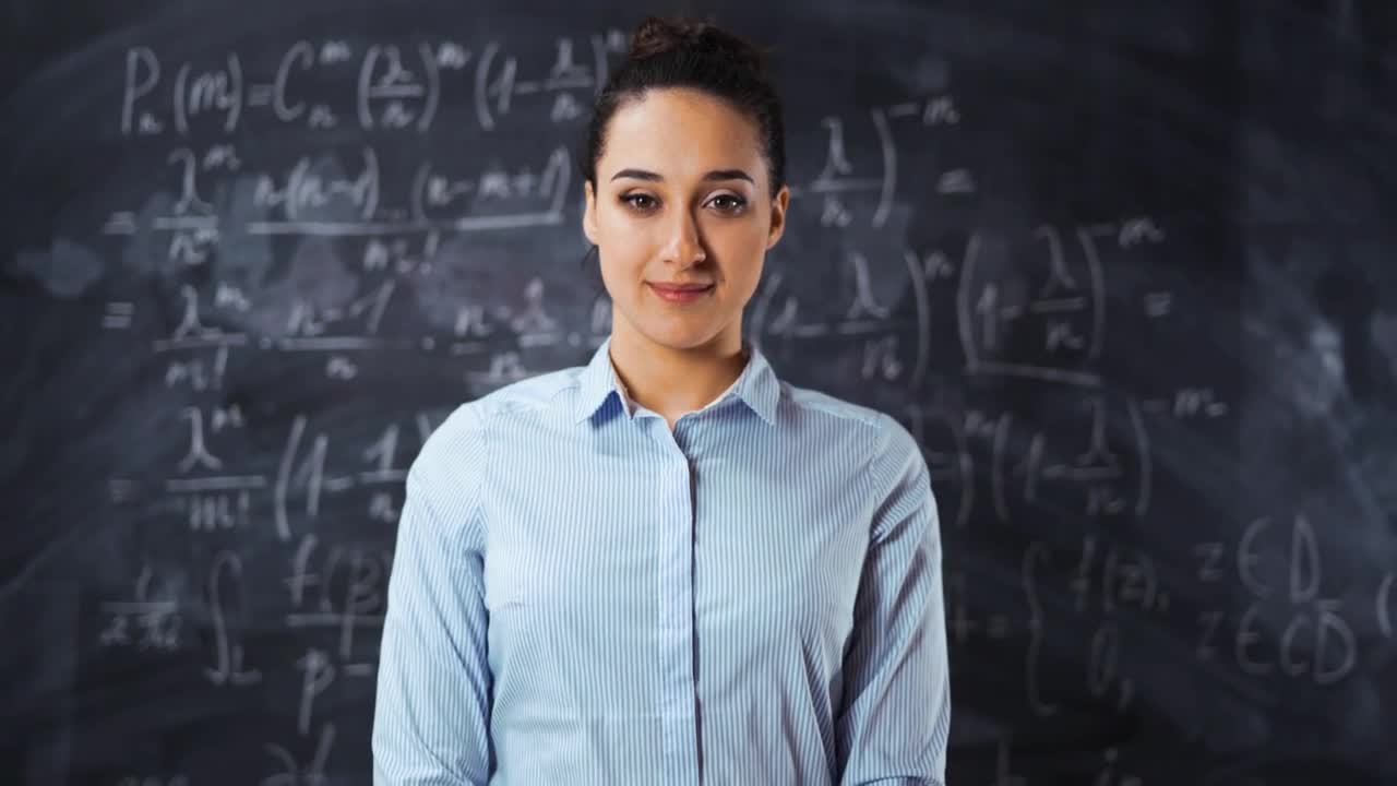 Free Video Stock teacher smiling in front of a blackboard Live Wallpaper