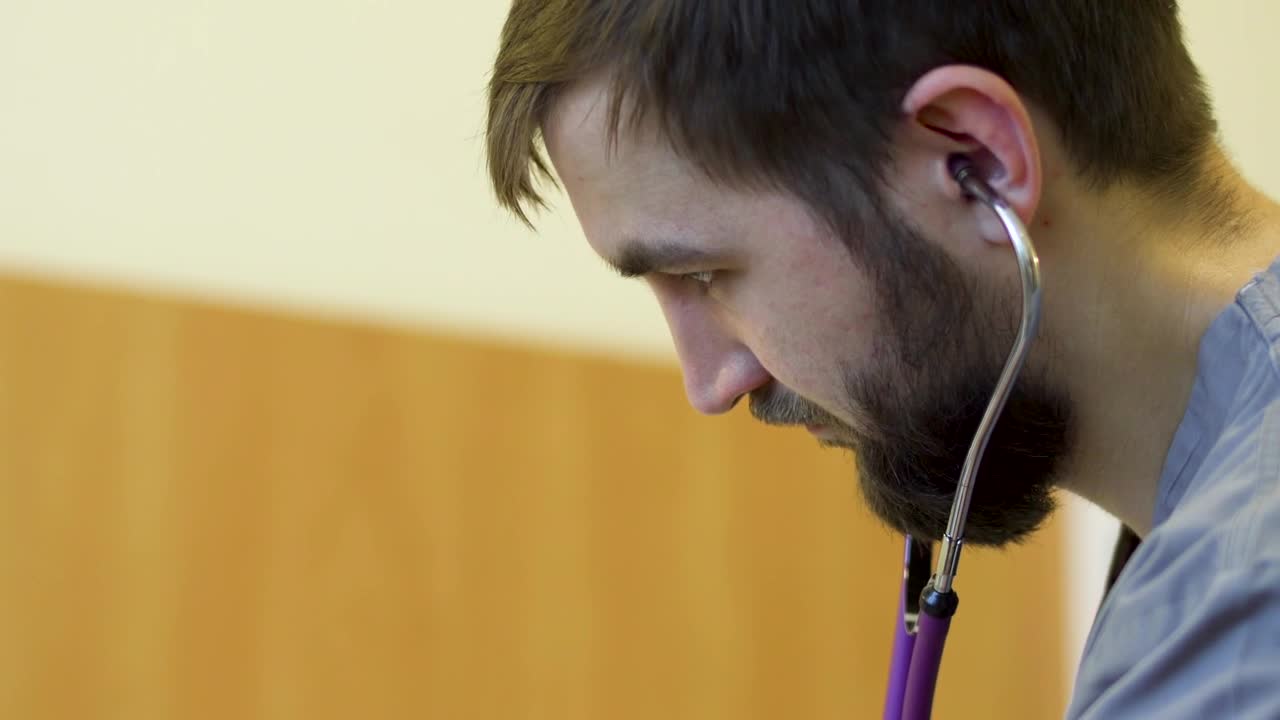 Stock Footage Young Doctor Listening Through His Stethoscope Live Wallpaper Free